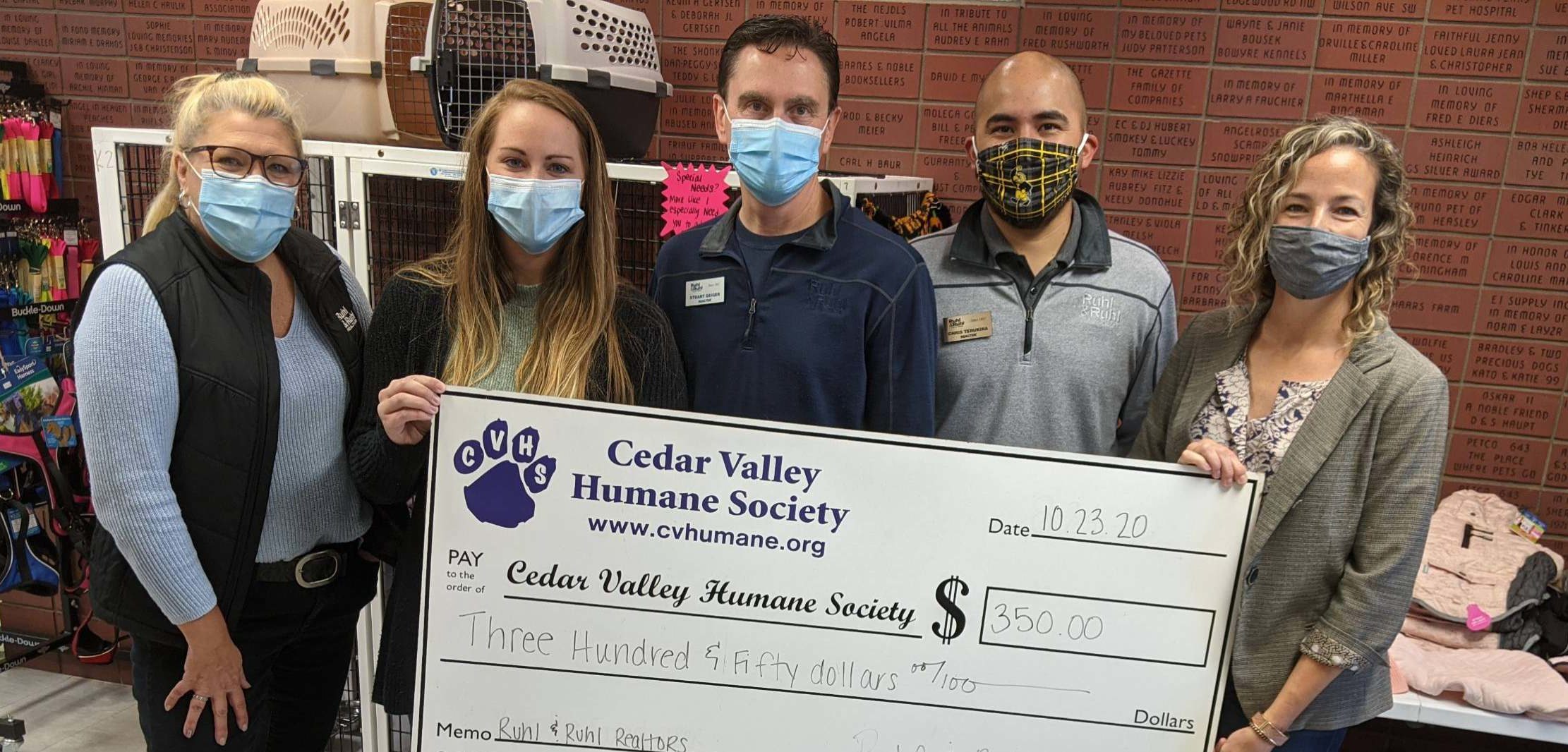 Agents present a check from Ruhl&Ruhl Realtors to the Cedar Valley Humane Society.